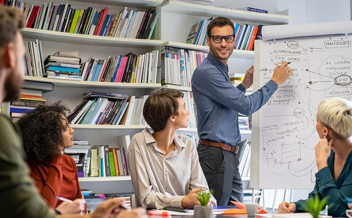 Enlightened leadership professional pointing at a whiteboard